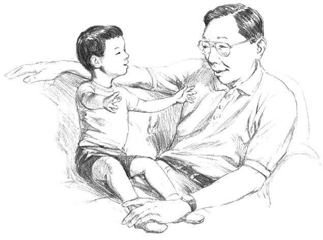 A young boy sits on his father's lap and tells a story.